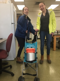 Cameron Peters and Jennie VanMeter put "the baby" (soil CO2 fluxmeter) in the stroller for a walk down to their forest research sites at the BFEC.